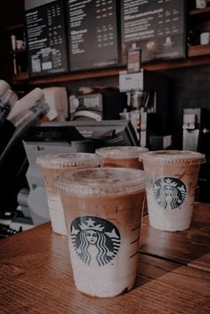 two cups of coffee sitting on top of a wooden table