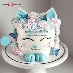 a birthday cake with a cat face and butterflies on it's head that says happy birthday any name here