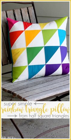 a colorful pillow sitting on top of a wooden bench next to a white wall with the words, super simple rainbow triangle pillow from half square triangles