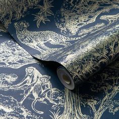 a blue and white wallpaper with an animal pattern on it's side, next to a roll of tape