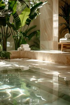 an indoor pool with plants and towels on the edge, in front of a large mirror