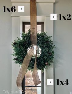 a christmas wreath hanging from the side of a door with measurements for it to be hung on