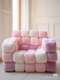 a pink and white couch sitting on top of a hard wood floor