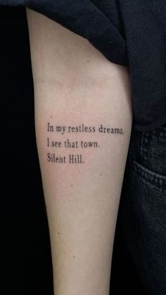 a person with a tattoo on their arm that reads, in my restless dreams, i see that town silent hill