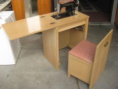 a sewing machine sitting on top of a wooden table next to a desk with a chair