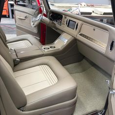 the interior of a car with beige leather and chrome trims, including an automatic steering wheel