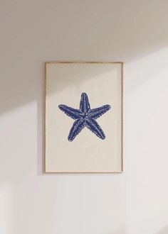 a blue and white starfish print hangs on the wall