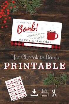 the hot chocolate bomb printable is displayed on a wooden table with pine branches and berries