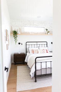 a bedroom with white walls and wood floors