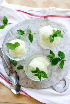 three small glass dishes with ice cream and mint