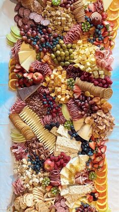 a very large platter filled with lots of different types of fruit and veggies