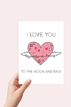 a hand holding up a card with the words i love you to the moon and back