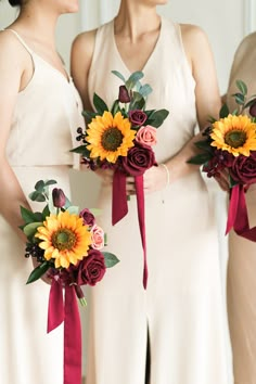 the bridesmaids are holding their bouquets with sunflowers and roses on them