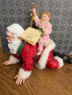 a figurine is sitting on top of santa claus's head and holding a bag