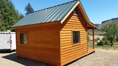 a small wooden cabin with a metal roof