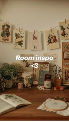 a wooden table topped with lots of pictures and papers on it's wall next to a potted plant