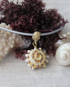 "These cute seashells are 100% handmade. They are carefully created from Murano glass. Tiny details make them so unique and realistic looking. This leather cord necklace will suit to any gender. The beads are about 20 x 12 mm. Bail is custom made from brass. Leather cord is 2 mm. Clasp is sterling silver in a claw shape. Recommended choker's length: - women 14 or 16\" - men 18 or 20\" All photos and designs are originally created by me and are exclusively the intellectual property of Styling By Round Shell As A Gift, Unique Handmade Shell Jewelry, Handmade Shell Necklace, Artisan Handmade Shell Craft, Unique Handmade Shell Gift, Handmade Shell For Jewelry Making, Unique Handmade Shell For Jewelry Making, Ocean-inspired Shell Necklace With Round Beads For Gift, Handmade Gold Round Shell