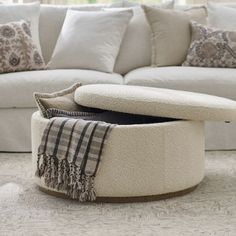 a living room with a white couch and ottoman