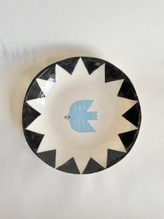 a black and white plate with a blue bird on it