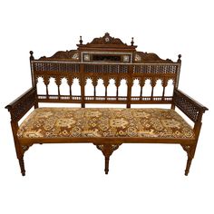 an ornate wooden bench with intricate carvings on the back and sides, against a white background