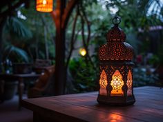 a lit lantern sitting on top of a wooden table in front of trees and plants