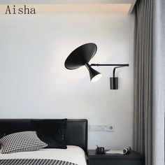 a black and white bedroom with a lamp on the wall