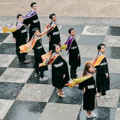 a group of young people standing on top of a checkered floor