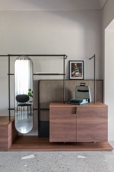 an office with a desk, chair and mirror