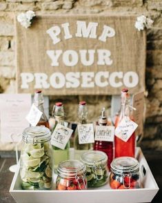 some jars filled with pickles sitting on top of a wooden table next to a sign