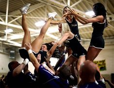 a group of women in cheerleader outfits standing on top of each other