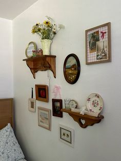 there are many pictures on the wall with flowers in vases and other things around them