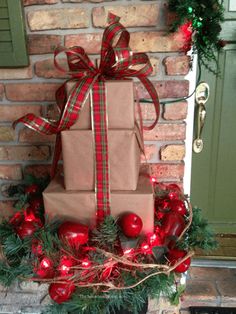 a christmas present wrapped in brown paper and tied with red ribbon sitting on top of a fireplace