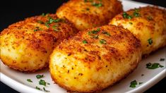 four pieces of fried food on a plate with parsley sprinkled on top