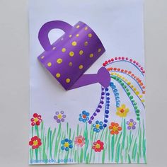 a purple watering can on top of a white paper with flowers and rainbows painted on it