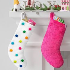 two christmas stockings hanging from a mantel