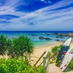 there are two surfboards on the steps to the beach