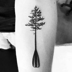 a black and white photo of a tree in a bottle tattoo on the left leg