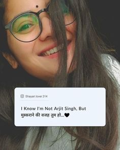 a woman wearing glasses and smiling in front of a sign that says, i love you