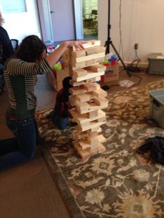 two women are playing with wooden blocks on the floor