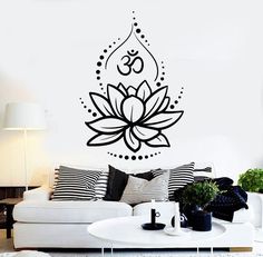 a living room with a white couch and black wall decal on the wall above it