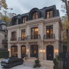 a black car parked in front of a large house