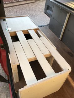 the back end of a truck with wooden slats on it's bed frame