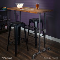 two stools and a table in front of a purple wall