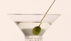 a martini glass with an olive in it and a stick sticking out of the top