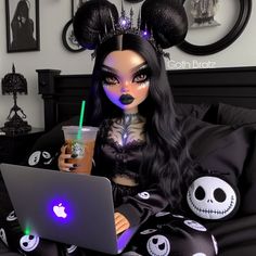 a doll sitting on a bed with a laptop and drink in her hand while holding a cell phone