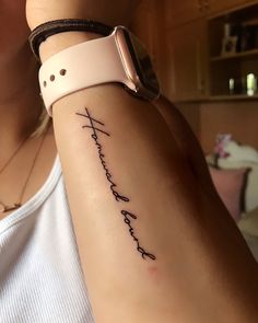 a woman with a wrist tattoo that says faith