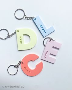 three different key chains with letters on them