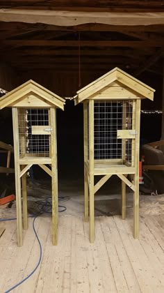 two wooden bird houses sitting on top of a wooden floor