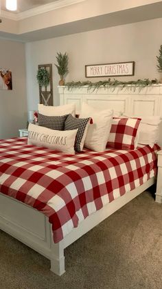 a red and white checkered comforter on a bed in a room with christmas decorations