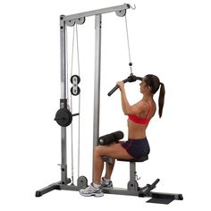 a woman squats on a bench while using a pull up bar in the gym